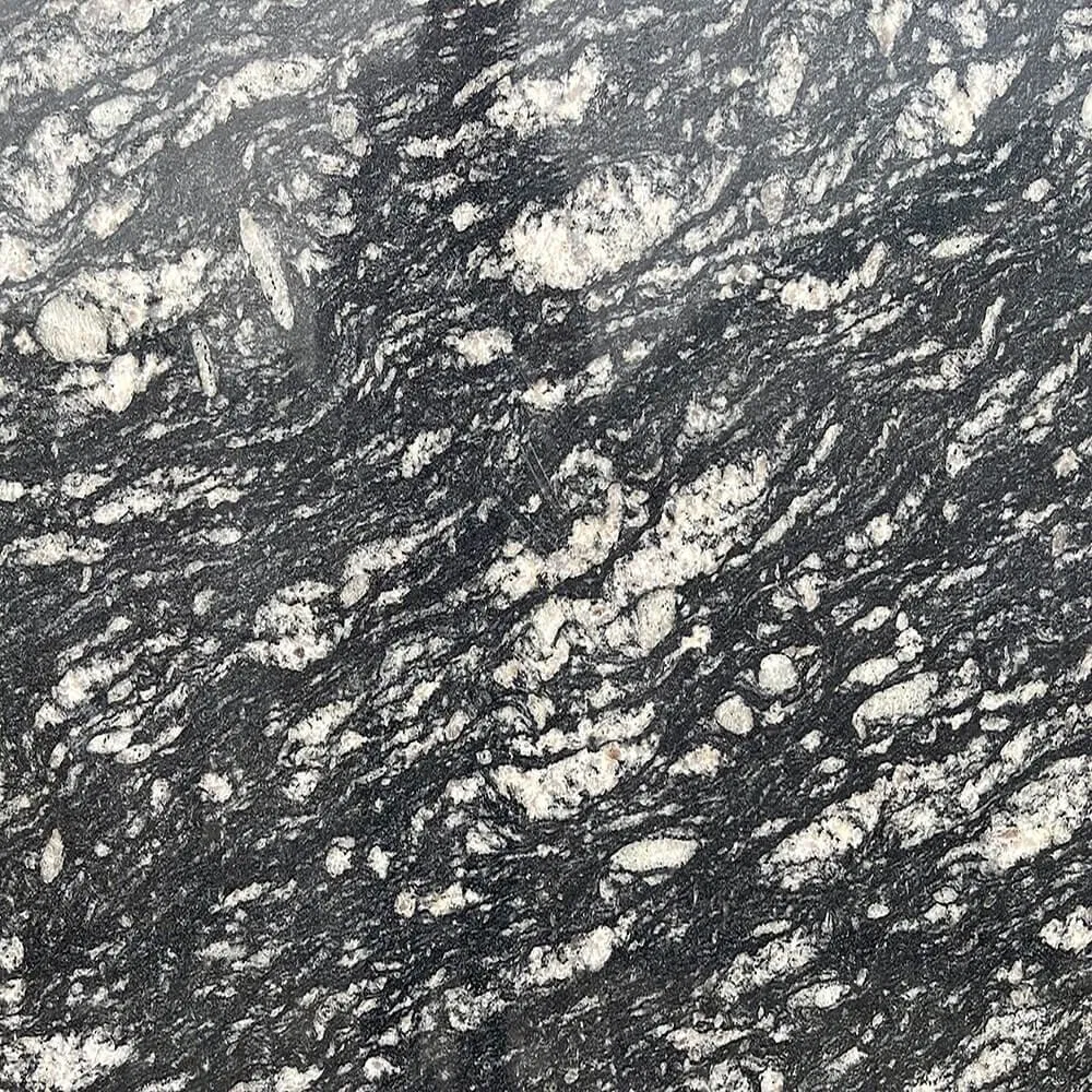 The Subtle Sophistication of Fish Black: Why Texture Trumps Flat Color in Modern Architecture 1 A modern corporate lobby featuring massive vertical wall panels of Fish Black Granite with a leathered finish, showing how the texture interacts with indirect lighting