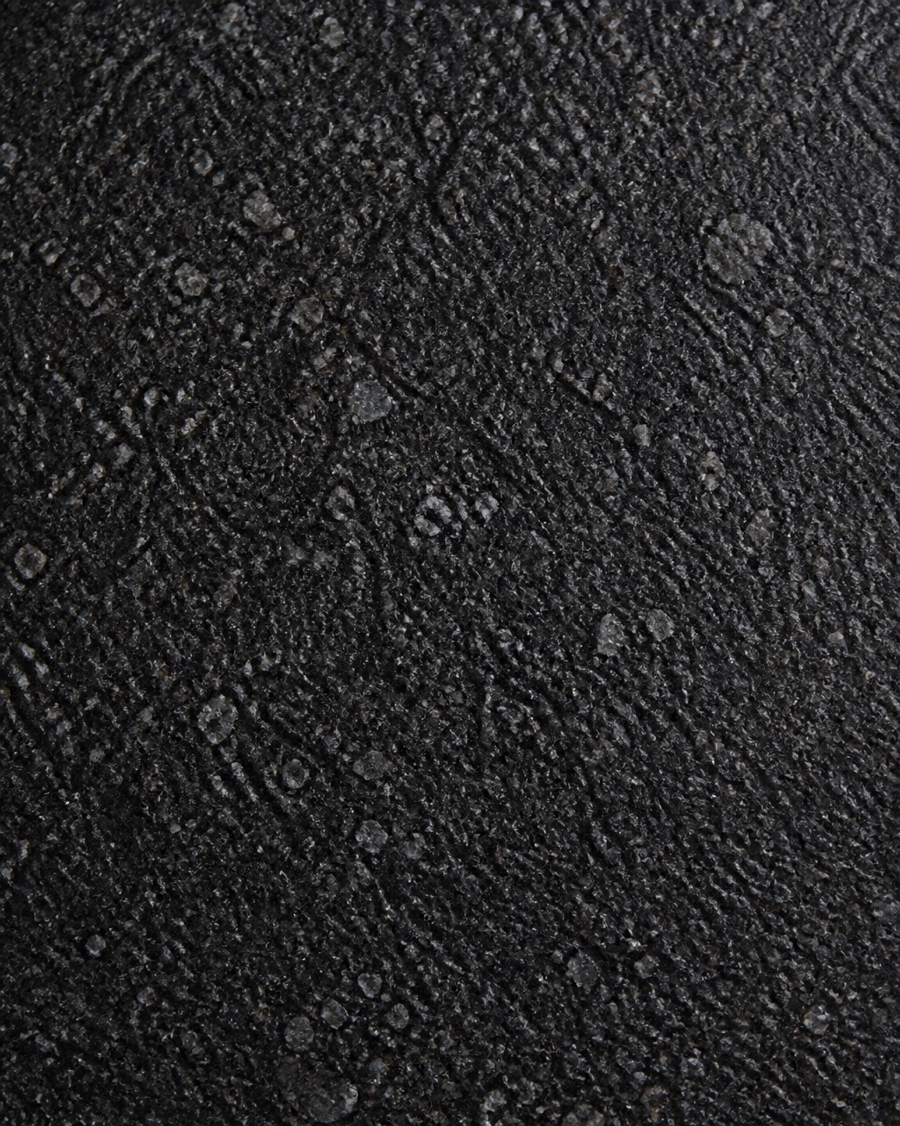 The Texture Revolution: How Leathered Black Forest Granite is Redefining Commercial Interiors 1 A macro close-up of a Leathered Black Forest Granite slab, highlighting its unique rippled and non-reflective texture.
