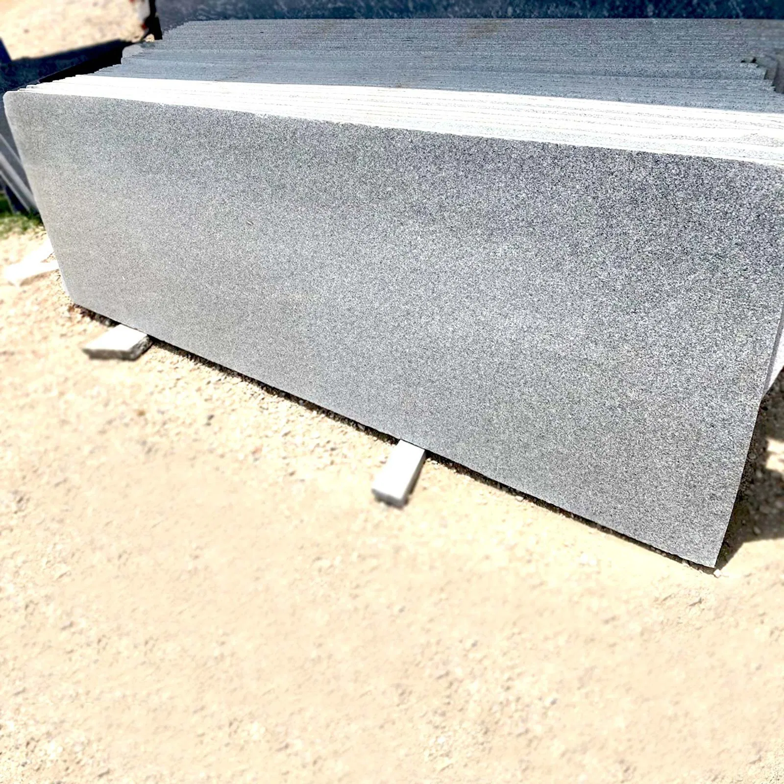 Exporting Excellence: How Stone Harbor Ensures Quality in Every Slab 3 A batch of uniform grey granite slabs showing consistent grain and precise edge finishing