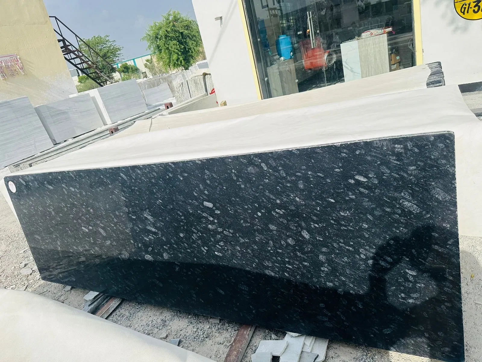 The Rise of "Quiet Luxury": Why Black Pearl Granite is the 2026 Choice for Minimalist Architects 1 Large raw block of premium black granite with distinctive silver speckle pattern