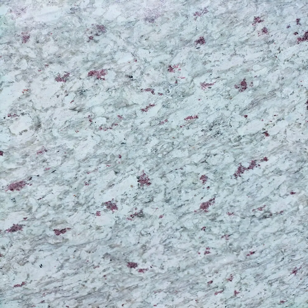 Beyond Aesthetics: The Durability of Kashmir White Granite in High-Traffic Commercial Spaces 1 Close-up of a New Kashmir White Granite slab showing the intricate texture of the white base and the signature dark garnet clusters