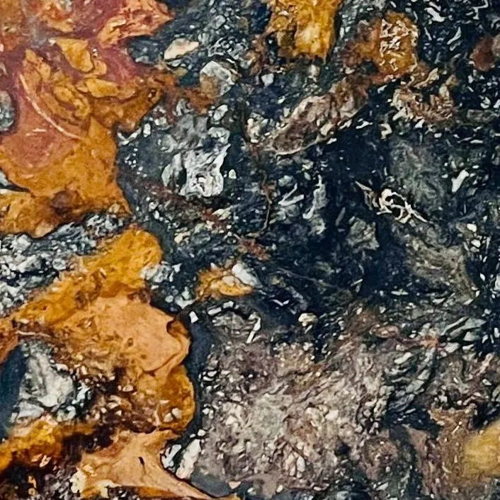Arizona Forest Marble close-up, charcoal black with molten ochre-gold and silver-grey flows, Stone Harbor Exports