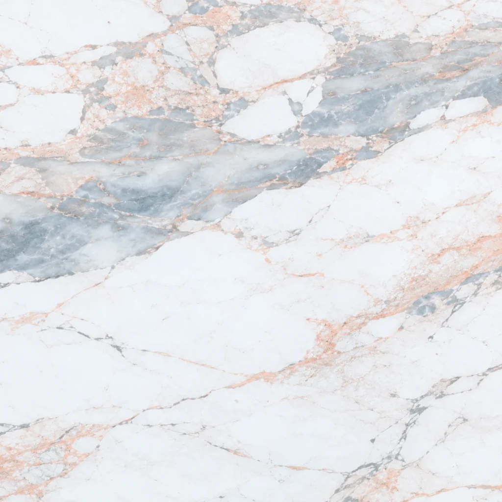 Calacatta marble close-up: bright white with blue-grey patches and copper veins
